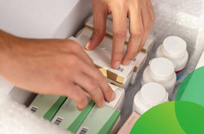 Myyntilupa-asiantuntija tutkii pakettia, joka sisältää useita eri lääkepakkauksia. Tuotemuutokset.